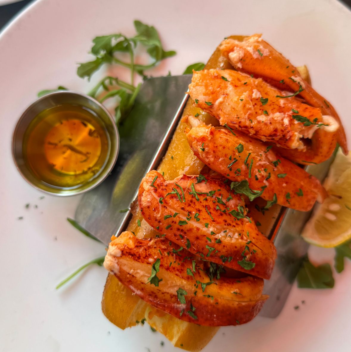 A Maine lobster roll with drawn butter and lemon